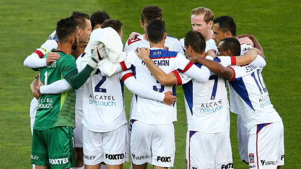 Newcastle Jets players form a huddle before their season opener against Wellington.